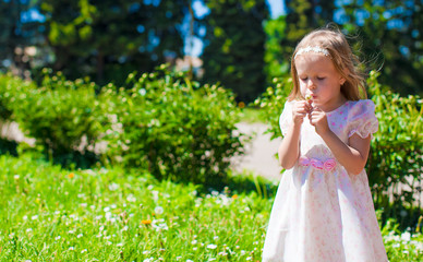 Little adorable girl enjoying beautiful day in blooming garden