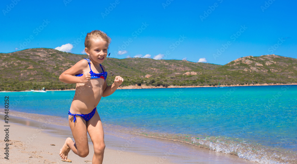 Wall mural adorable little girl have fun on tropical white sandy beach