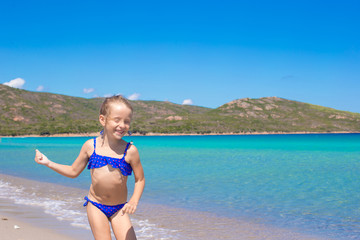 Adorable little girl have fun on tropical white sandy beach