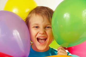 Little smiling boy between the festive balls