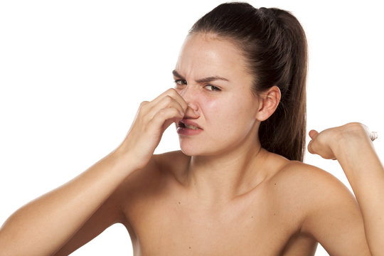 young woman pinching her nose because of the smell