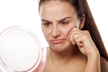 unsatisfied young woman in front of mirror