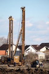 construction site with workers and hydraulic drilling machines