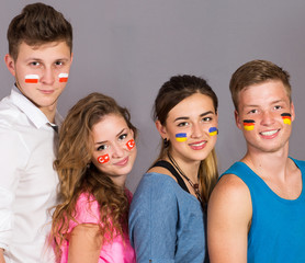 Four teenagers with flags drawn on the faces