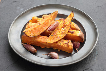 Sweet potato roasted chips on a tin plate.