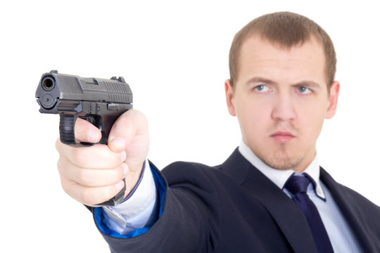 serious man in business suit shooting with handgun isolated on w