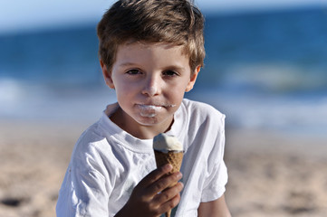 Portrait of a boy on the beach, eating ice cream