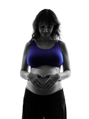 pregnant woman forming heart shape on belly silhouette