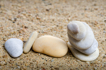 Fototapeta na wymiar Stones stacked in sand background