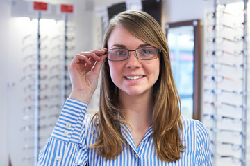 Woman Trying On New Glasses In Opticians