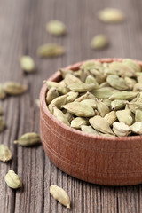 Green cardamom ayurveda aroma spice in a wooden bowl on vintage