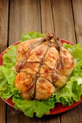 Bondage shibari roasted chicken with salad leaves on red plate o