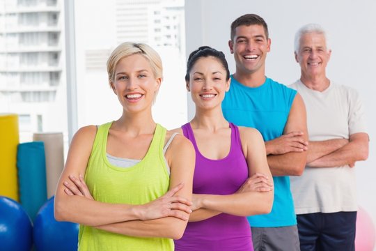 Fit people standing arms crossed at gym