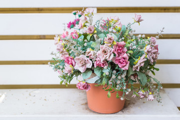 Fototapeta na wymiar Artificial flowers in the basket in vintage theme