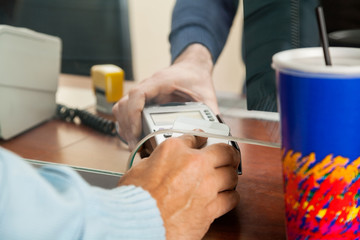 Man Using NFC Technology To Pay For Movie Tickets