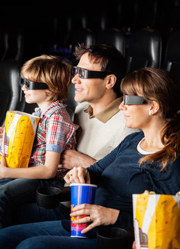 Family Having Snacks While Watching 3D Movie