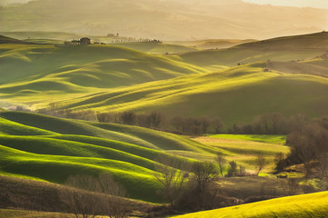 Spring wonderful landscape of Tuscany, green fields, sunrise and