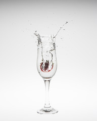 Strawberry falls deeply under water with a splash
