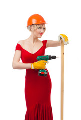 Beautiful blonde in a red dress with an electric drill