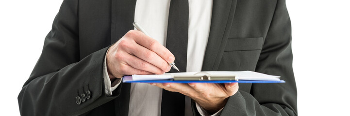 Writing notes on paper in clipboard folder
