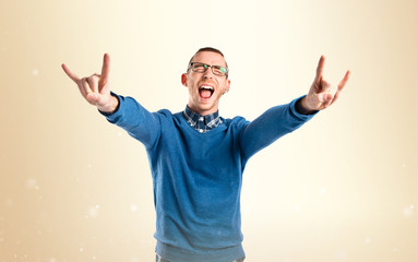 Young man doing the horn gesture over white background