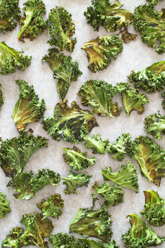 Baked Curly Kale Chips on Baking Tray Lined with Paper