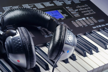 Obraz na płótnie Canvas Headphones on top of a synthesizer buttons