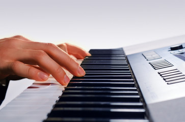 man playing on a synthesizer, isolated on a gradient gray