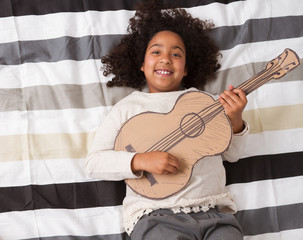Childen playing with his guitar cardboard.