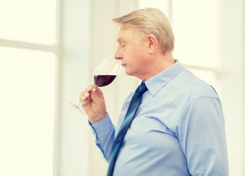 Older Man Smelling Red Wine