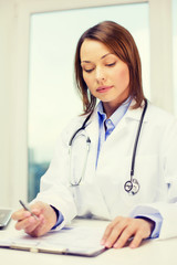 busy doctor with laptop computer and clipboard