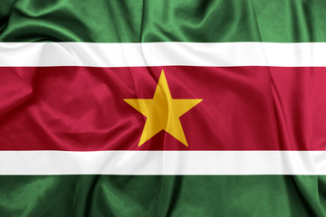 Obraz premium Suriname - Waving national flag on silk texture