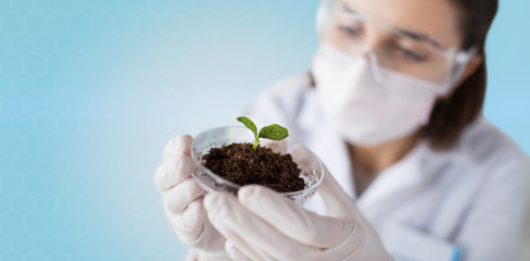 close up of scientist with plant and soil