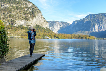 photographer standing on wooden bridge and taking the lake view