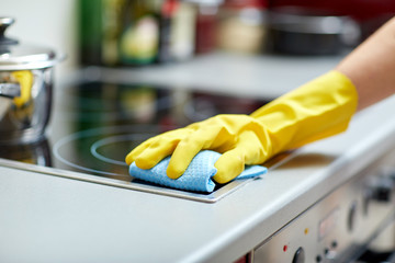 close up of woman cleaning cooker at home kitchen