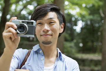 A man taking a picture with camera in park