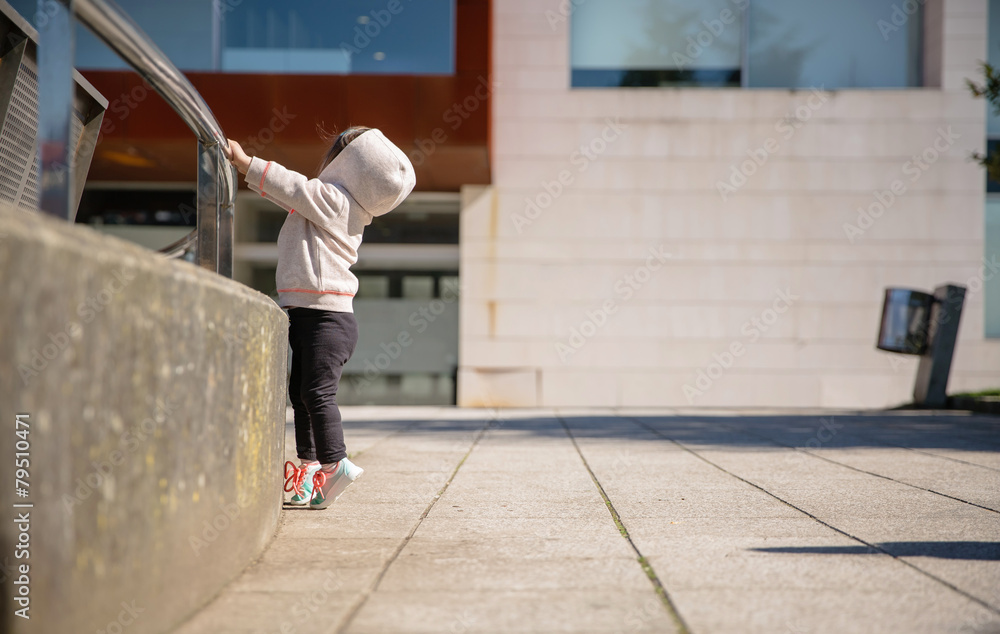 Wall mural Little girl with sneakers and hoodie training outdoors - Wall murals