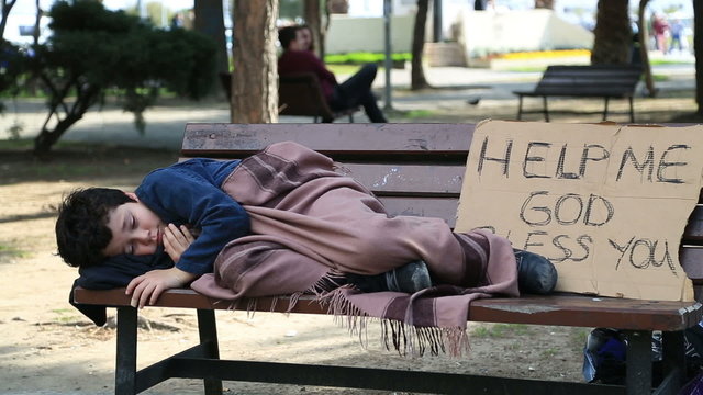Homeless, sick child lying on bench