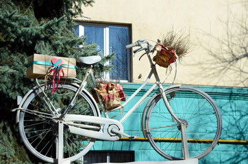 Old bicycle with presents on building background