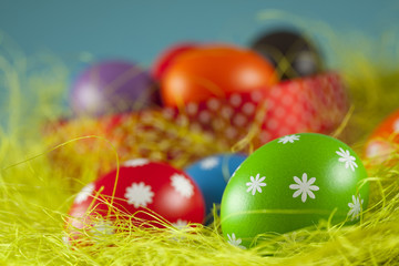 Colored Easter eggs on the grass and blue sky background