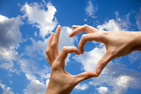 Hands with heart shape on the sky