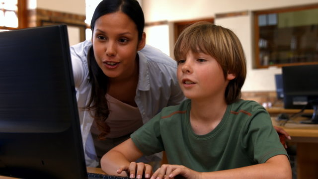 Pupil and teacher in computer class at school