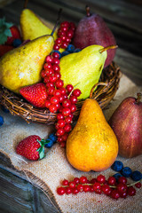Pears with berries on wooden background