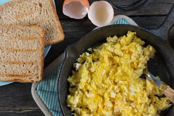 scrambled eggs in vintage frying iron pan, overhead view