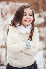 winter portrait of adorable child girl in snowy forest