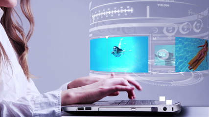 Woman using laptop with holidays hologram interface - Powered by Adobe