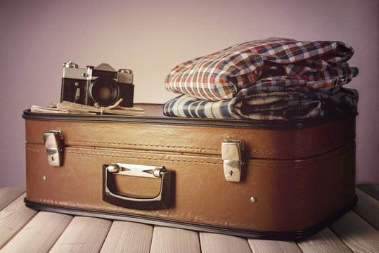 Vintage suitcase with clothes and camera