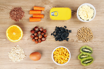 Various food products containing vitamins on wooden background