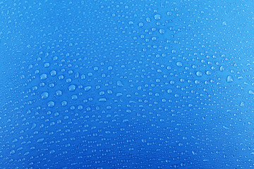 Water drops on glass on blue background