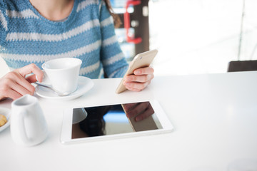 Woman at the cafe using a mobile phone